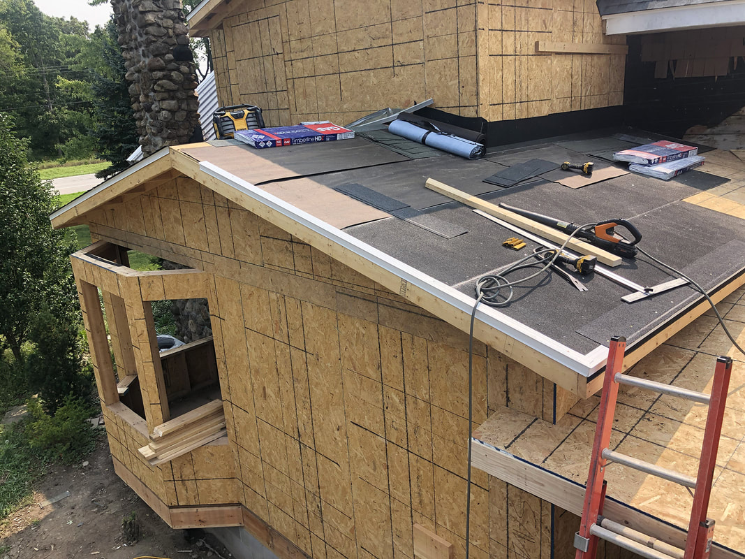 New home construction showing roof installation, OSB sheathing, and active exterior framing work by Fournier Construction &amp; Excavation.